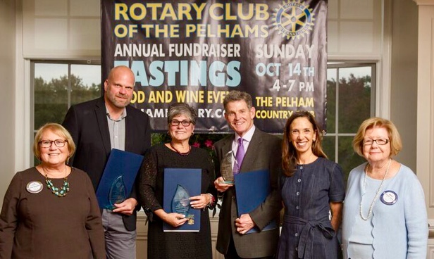 Honorees Clay Bushong, Josephine Catalano and Syd Thayer, holding blue citation folders from Assemblymember Amy Paulin, with Rotary President Lyn Roth Jacobs (far left) and Rotary Tastings Committee Chair Betty Bucher (far right)