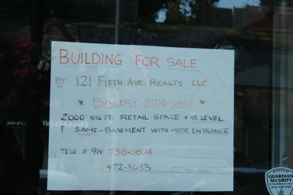 Building for sale sign posted on Pelham Bakery door. 