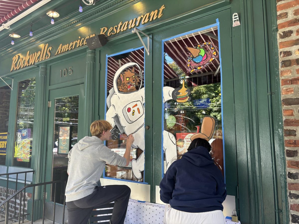 Foto Feature: PMHS art students paint Halloween storefront windows with outer space theme